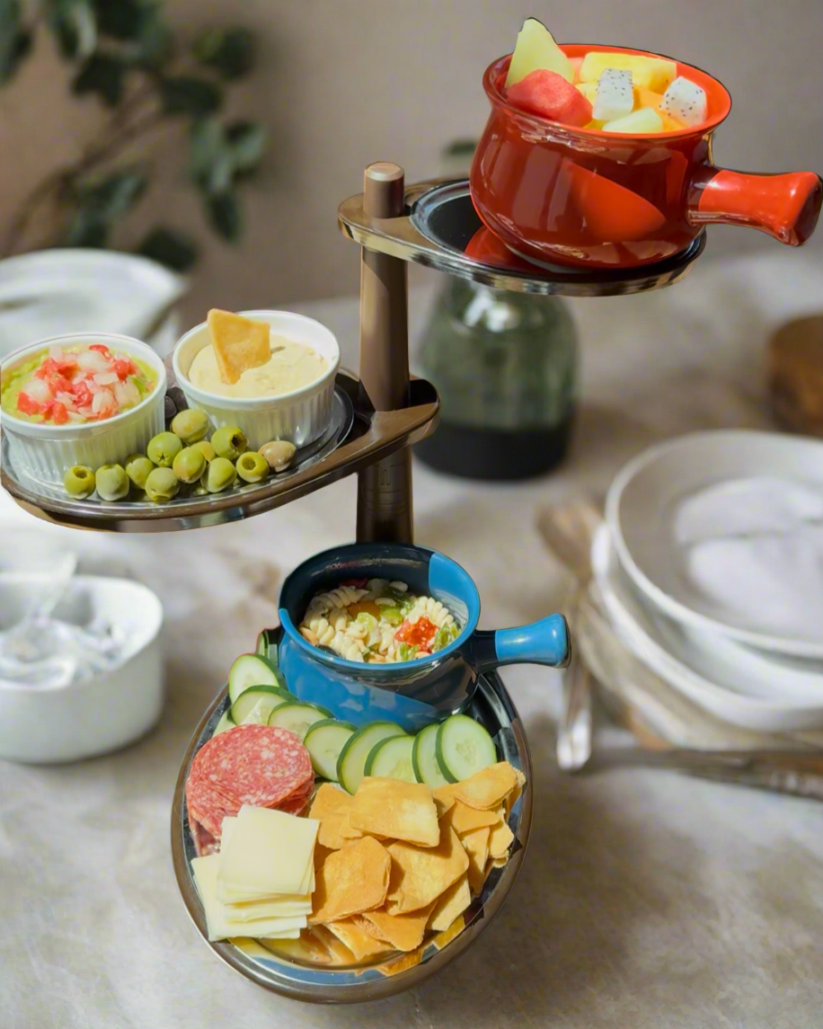 Dessert platter with fruits, cookies, and a teapot on a wooden table.